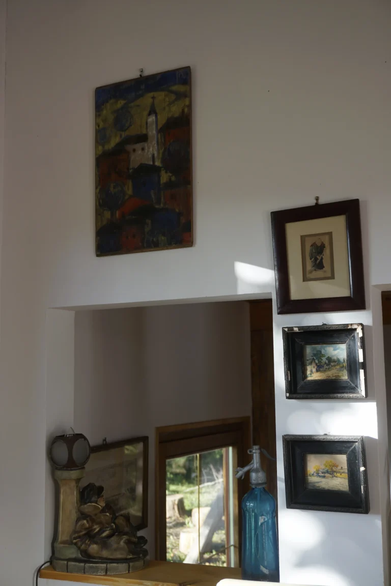 Dekorációs részlet polcon a ZegZug vendégházban, üvegekkel és képekkel