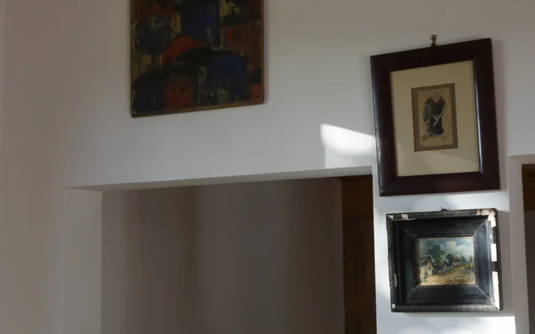 Dekorációs részlet polcon a ZegZug vendégházban, üvegekkel és képekkel