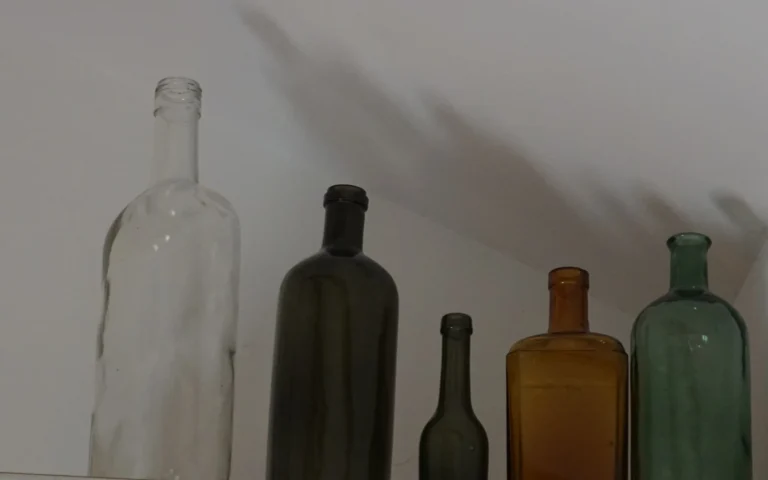 Üvegek és dekorációs részlet a ZegZug vendégházban, természetes fényben